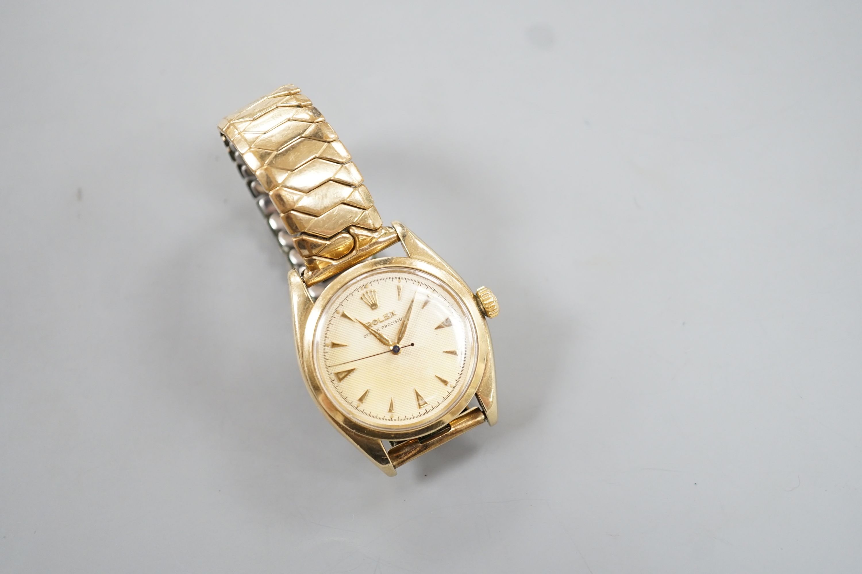 A gentleman's 1950's 9ct gold Rolex Oyster Precision manual wind wrist watch, with honeycomb dial and baton numerals, on associated expanding bracelet, case diameter 35mm, with personalised inscription to case back, no b